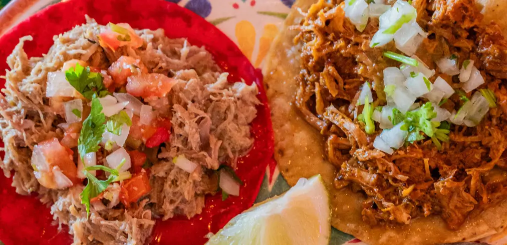 Dos tacos de carnes, con cebolla y tomate