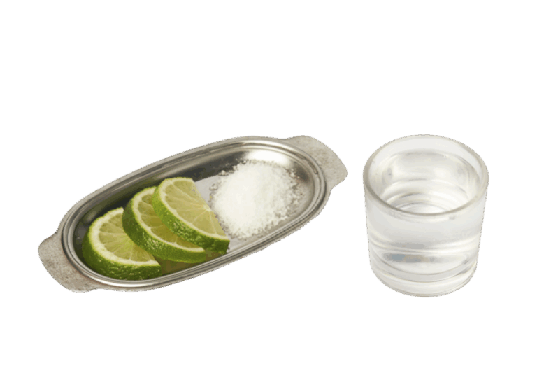 Un shot de tequila y una bandeja con limon y sal